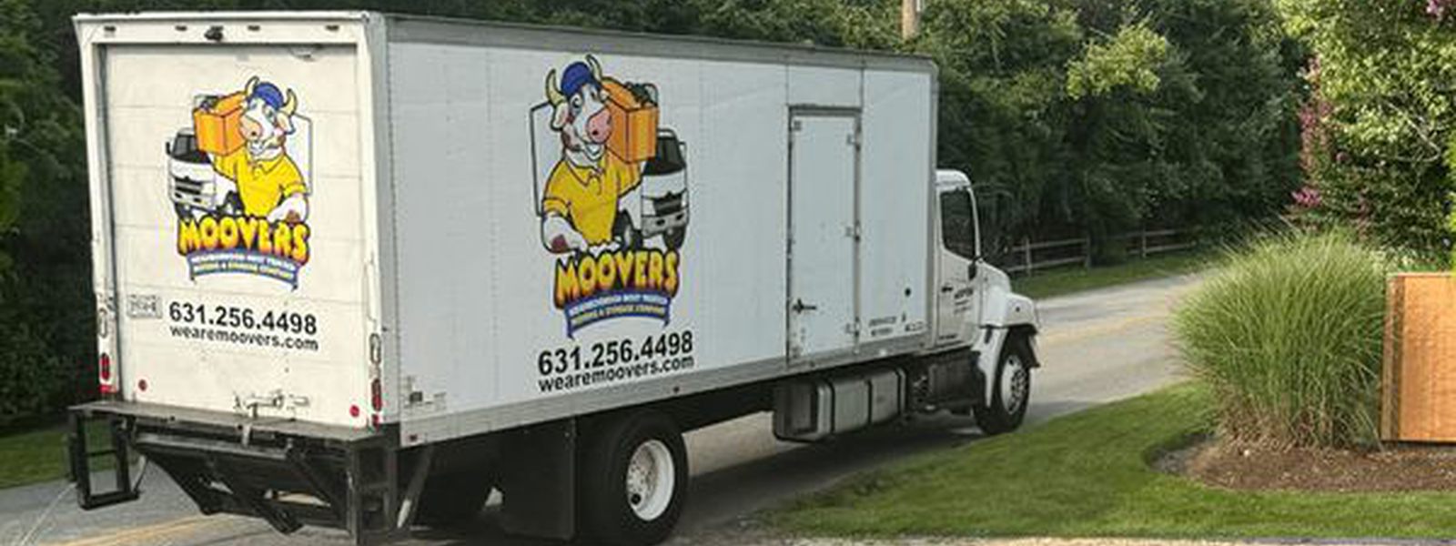 A Moovers crew member carrying a wrapped carton out to the truck